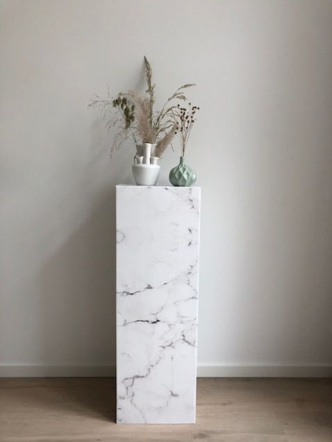 Cardboard pillar with white marble print. A real eye-catcher to show your accessories or products. Easy to fold, unfold, use, reuse and to carry